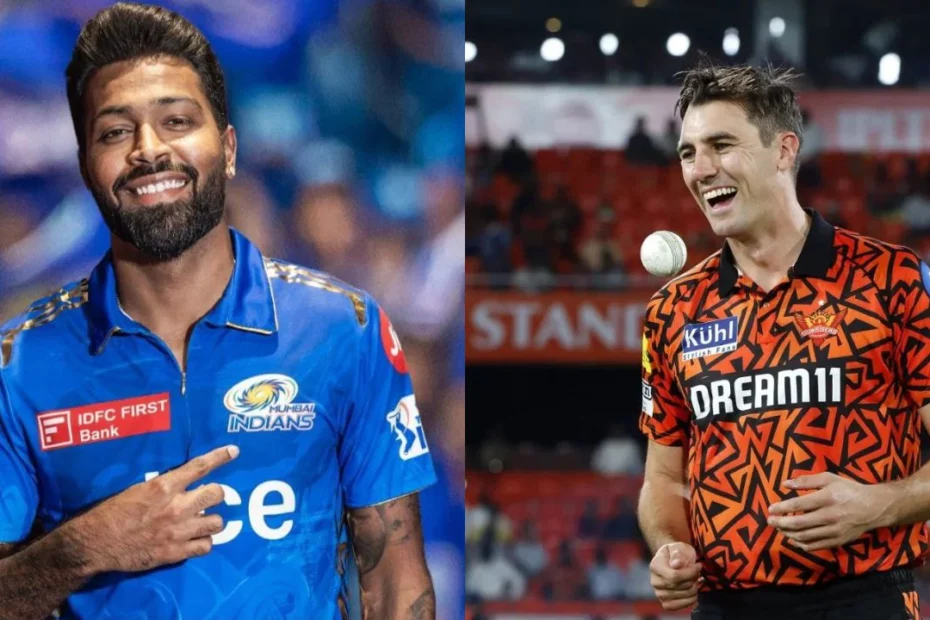 Two cricketers stand side by side: left in blue Mumbai Indians jersey smiling with a hand on his chest, right in orange Dream11 jersey smiling on the field.